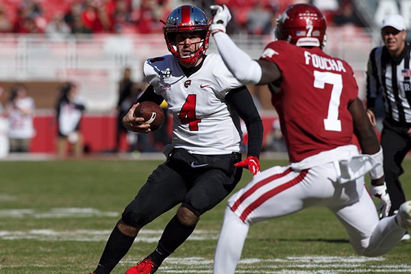 Western Kentucky quarterback Ty Storey (4) runs with the ball as Arkansas defensive back Joe Foucha (7) pursues during a game Saturday, Nov. 9, 2019, in Fayetteville.