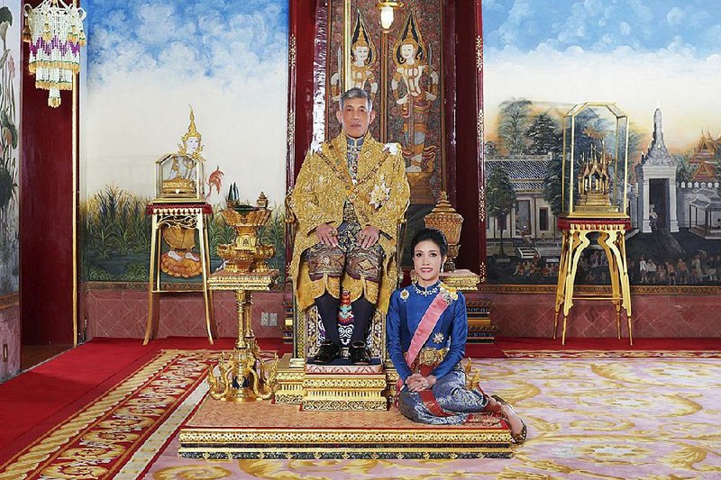 Thailand’s King Maha Vajiralongkorn sits on the throne in the royal palace in Bangkok with his official consort, Sineenatra Wongvajirabhakdi, in this undated photo. Sineenatra was stripped of her official duties after being accused of trying to upstage the queen. 