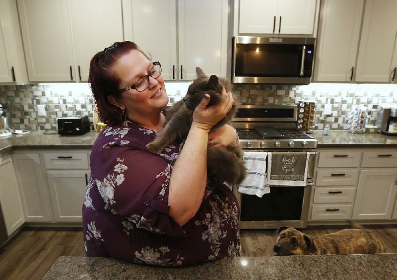 At her recently rebuilt home in Paradise, Claif., on Tuesday, Victoria Sinclaire holds her cat Toby, that survived the Camp Fire. 