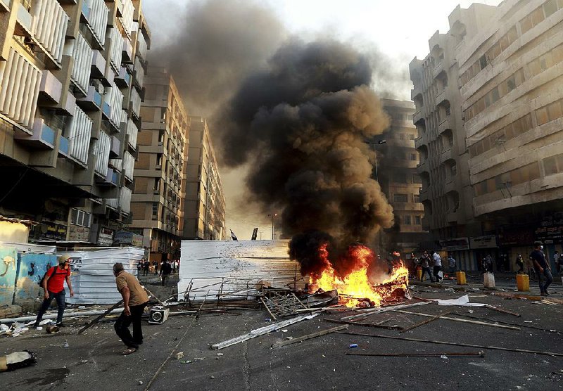 Anti-government protesters set fires and barricade streets Saturday in Baghdad. 