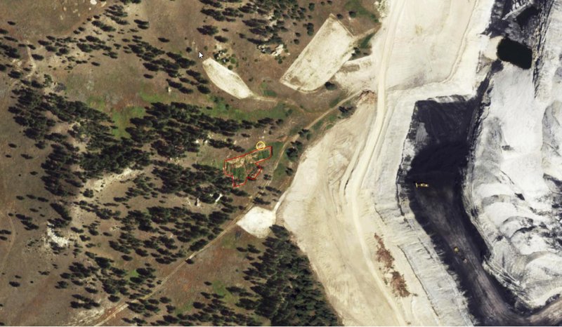 This undated recent aerial photo from the Montana State Library shows shows an area of a Westmoreland Energy coal mine near Sarpy Creek in eastern Montana. The graphics, added by the library, show the general area of excavation, framed in red, and a bison bone pile, framed in yellow. When the coal company dug up a huge bison killing grounds on the Crow Indian Reservation with a backhoe to make way for mining, investigators determined the damage violated federal law and would cost $10 million to repair, documents show. But nothing happened - no fines, no repairs and no compensation. (Montana State Library via AP)