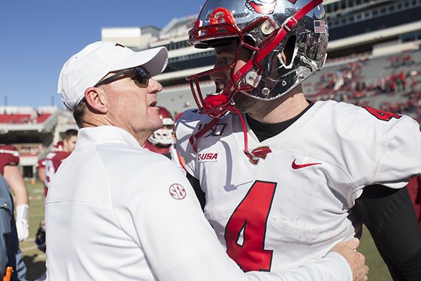 Arkansas coach Chad Morris (left) talks with Western Kentucky quarterback Ty Storey following a game Saturday, Nov. 9, 2019, in Fayetteville. Storey, who began his career at Arkansas and started nine games last season for Morris' Razorbacks, accounted for three touchdowns in the Hilltoppers' 45-19 victory. 