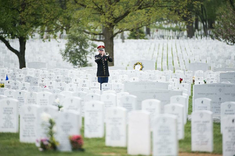 Staff Sgt. J. Martin “Marty” Bishop of Jonesboro, a member of the U.S. Army Band known as “Pershing’s Own,” plays taps earlier this year during a graveside service at Arlington National Cemetery in Virginia. 
