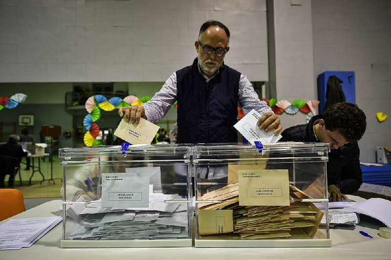 A polling-station worker sorts votes Sunday in Pamplona, Spain. More photos are available at arkansasonline.com/1111spain/ 