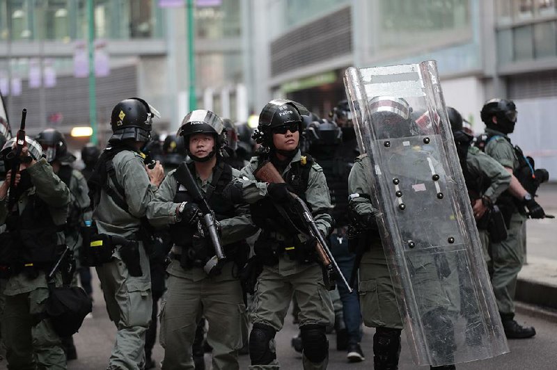 Hong Kong riot police take up defensive positions after an object was thrown at them during protests Sunday. 