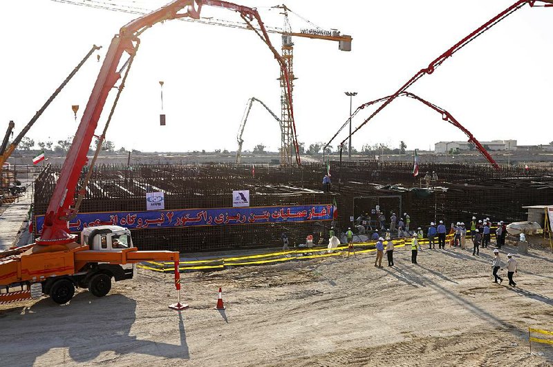 A banner reading “Beginning of operation of pouring of second reactor of Bushehr nuclear power plant” is displayed Sunday as cement is poured at the facility in Iran. 