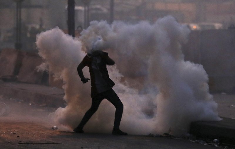 An anti-government protester is surrounded by tear gas fired by Iraqi security forces in an effort to disperse demonstrators, in central Baghdad, Iraq, on Sunday. - AP Photo/Hadi Mizban
