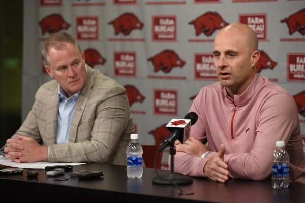 University of Arkansas Athletic Director Hunter Yurachek (left) listens to new interim head coach Barry Lunney Jr. on Monday, November 11, 2019, during a press conference at the Broyles Athletic Center in Fayetteville. Lunney is replacing Chad Morris, who was fired on Nov. 10.