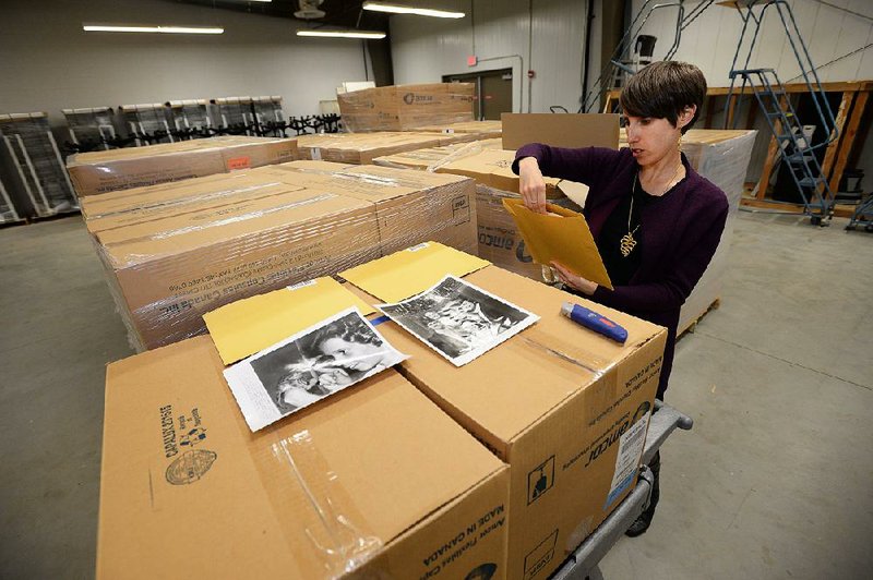 Lori Birrell, head of the Special Collections department at the University of Arkansas library, shows a few of the New York Post photographs that were donated to the campus in Fayetteville. 