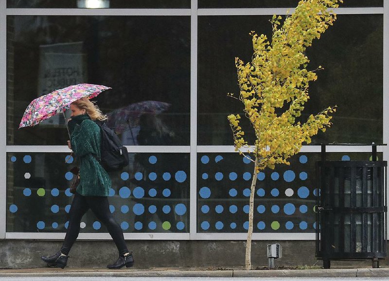 A pedestrian takes cover under her umbrella Monday in Little Rock’s River Market District.