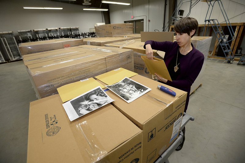 NWA Democrat-Gazette/ANDY SHUPE Lori Birrell, head of Special Collections at the University of Arkansas, shows a few of the New York Post photographs that were donated to the campus in Fayetteville.