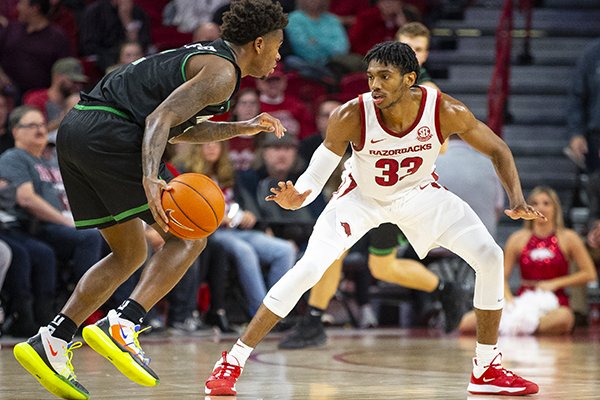 Arkansas guard Jimmy Whitt (33) defends North Texas guard Javion Hamlet (3) during a game Tuesday, Nov. 12, 2019, in Fayetteville.