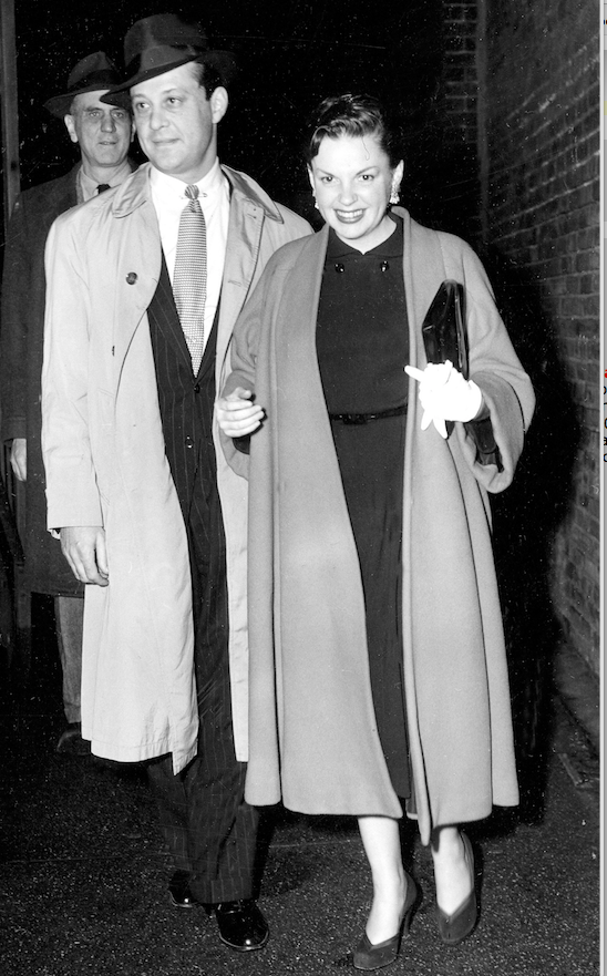 Actress-singer Judy Garland is accompanied by her manager and producer Sid Luft as she enters the stage door to New York's Palace Theater, on November 16, 1951. (AP)