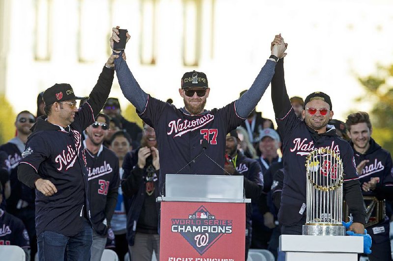 Washington Nationals pitcher and World Series MVP Stephen Strasburg, celebrates the World Series baseball championship during a rally following a parade to celebrate the team's World Series baseball championship over Houston Astros, Saturday, Nov. 2, 2019, in Washington. Nationals right fielder Gerardo Parra is right and pitcher Anibal Sanchez, left. 
