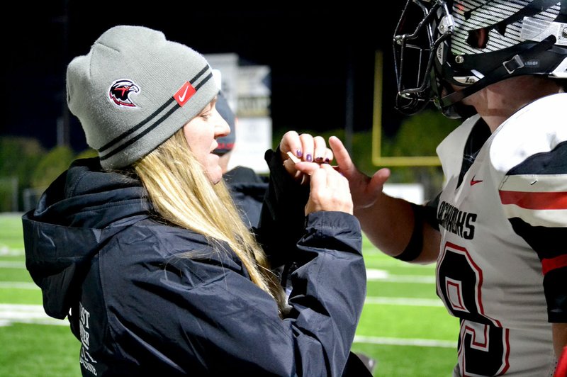 TIMES photograph by Annette Beard Dr. Jaime Mann, trainer for the Blackhawks, bandaged Adam Trammel's finger Friday night during the game at Shiloh.