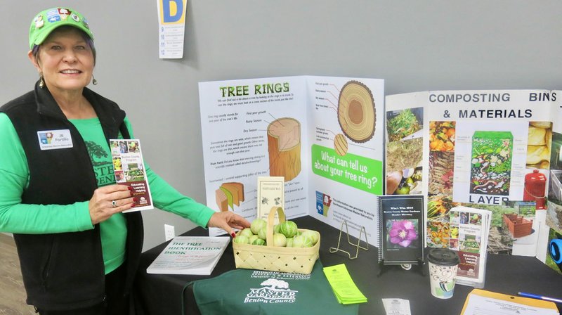 Westside Eagle Observer/SUSAN HOLLAND JB Portillo, of Bella Vista, a certified master gardener and a member of the Benton County Master Gardener program, displays some material explaining the Master Gardener program, its mission and training program. Portillo also shows off some miniature gourds grown in the area at her exhibit at the Gravette Lions Club's Live and Learn program Saturday, Nov. 9, at the Gravette Civic Center. She provided information about recommended species for planting by local gardeners.