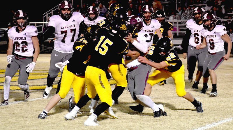 MARK HUMPHREY ENTERPRISE-LEADER Lincoln junior Noe Avellaneda pressed into action at quarterback due to injuries gets gang-tackled by a swarm of Prairie Grove defenders. The Tigers defeated the Wolves, 34-14, Friday to nail down a playoff spot while Lincoln was eliminated. Prairie Grove goes to Hamburg Friday for a first-round playoff game.