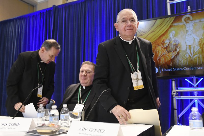 Archbishop Jose H. Gomez, right, of Los Angeles, with Bishop Michael F. Burbidge, left, of Arlington, Va., and Cardinal Joseph William Tobin, of Newark, N.J., exits a news conference after being elected president of the United States Conference of Catholic Bishops during their Fall General Assembly on Tuesday, Nov. 12, 2019 in Baltimore. (AP Photo/Steve Ruark)