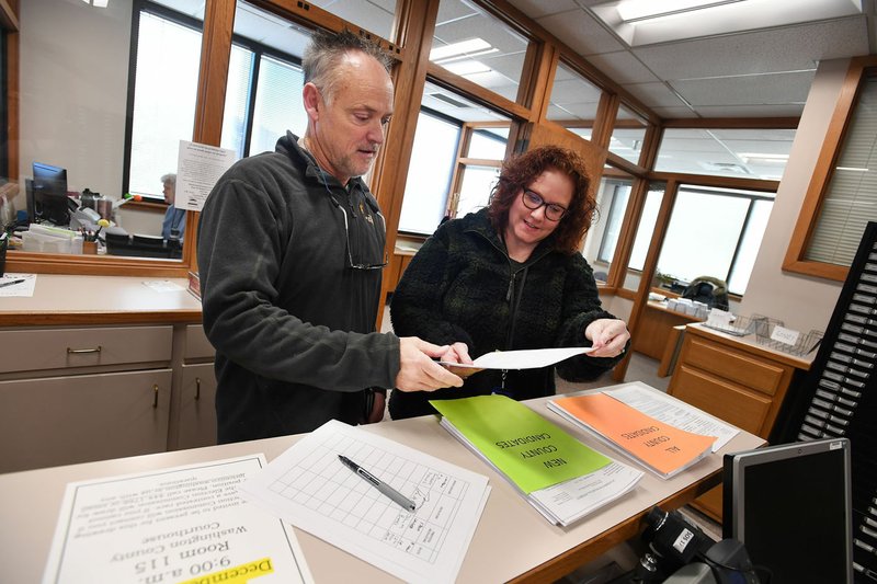 NWA Democrat-Gazette/J.T. WAMPLER Jennifer Sharpshair, deputy county clerk, helps John Brooks (left) of Fayetteville on Tuesday file to run for District 2 constable at the Washington County Courthouse in Fayetteville. Tuesday was the last to file the paperwork to run for public office.