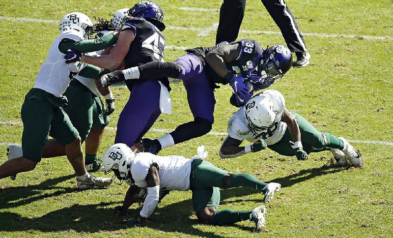 Baylor safety Will Williams upends TCU running back Sewo Olonilua on Saturday. The Bears have given up more than 20 points in regulation only once this season after allowing 32 points per game last season. 
