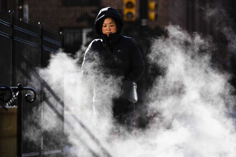 A woman bundled up against the cold walks on an autumn morning in Philadelphia, Wednesday, Nov. 13, 2019. An arctic blast that sent shivers across the Midwest spread to the eastern U.S. on Wednesday, with bitter weather establishing new records from Mississippi to Maine. (AP Photo/Matt Rourke)