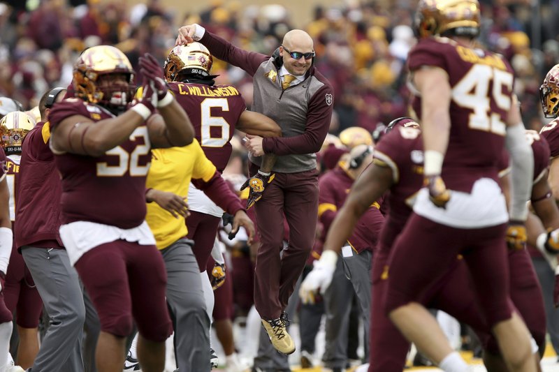 Minnesota head coach P.J. Fleck, center, jumps in celebration with defensive back Chris Williamson after the defense stopped the ball against Penn State during an NCAA college football game Saturday, Nov. 9, 2019, in Minneapolis. Minnesota won 31-26. (AP Photo/Stacy Bengs)