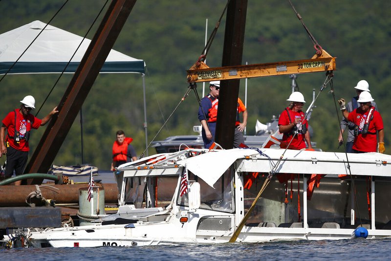 In this July 23, 2018 file photo, a duck boat that sank in Table Rock Lake in Branson, Mo., is raised after it went down the evening of July 19 after a thunderstorm generated near-hurricane strength winds, killing 17 people. The National Transportation Safety Board on Wednesday, Nov. 13, 2019, released a "Safety Recommendation Report" on the accident. The NTSB says the Coast Guard has repeatedly ignored safety recommendations that could have made tourist duck boats safer and potentially prevented the accident. (Nathan Papes/The Springfield News-Leader via AP, File)