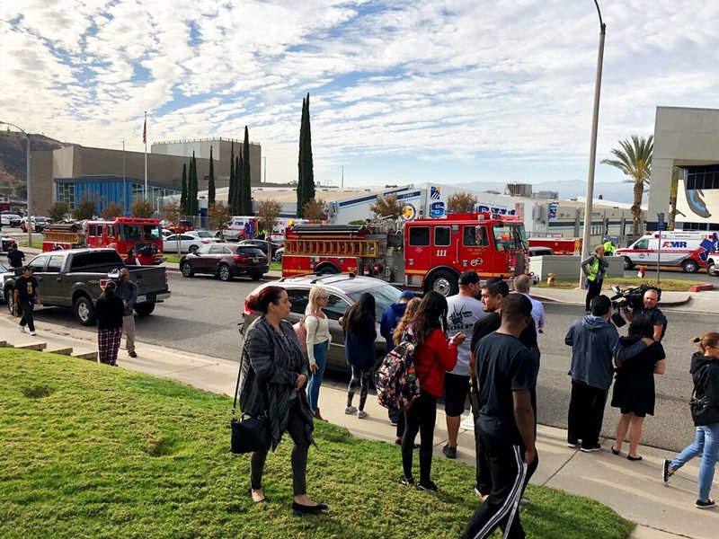 People wait for students and updates outside of Saugus High School after reports of a shooting on Thursday, Nov. 14, 2019, in Santa Clarita, Calif. (AP Photo/Marcio Jose Sanchez)