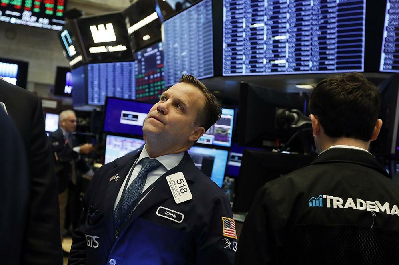 Trader John Elliott works Thursday on the fl oor of the New York Stock Exchange. A mixed bag of U.S. economic data resulted in a day of listless trading, although the S&P 500 notched another record. 