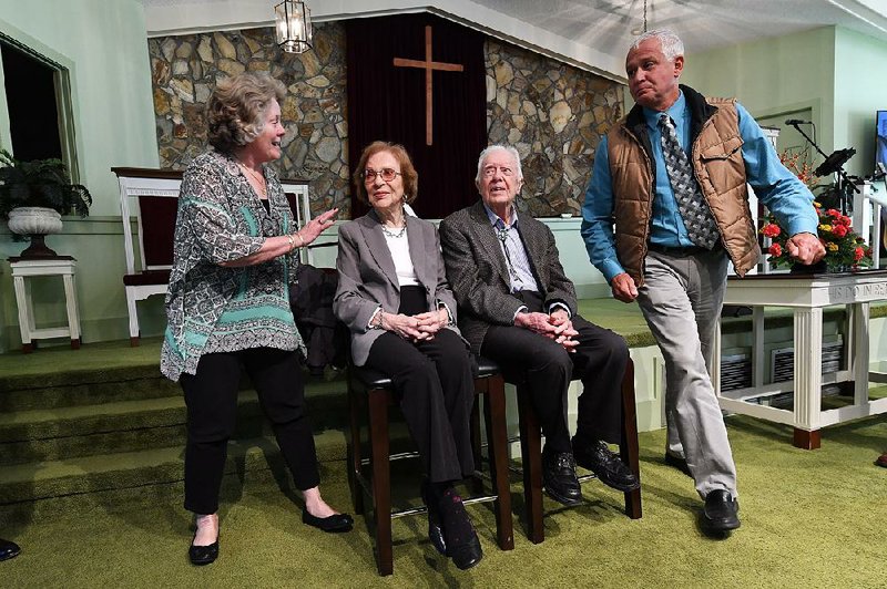 Former President Jimmy Carter (second from right) and former first lady Rosalynn Carter sit, as guests Ramona Kluth (left) and husband Doug Kluth, from Nebraska, finish their turn of having their photo made with them on Nov. 3, after Sunday School at Maranatha Baptist Church, in Plains, Ga. 