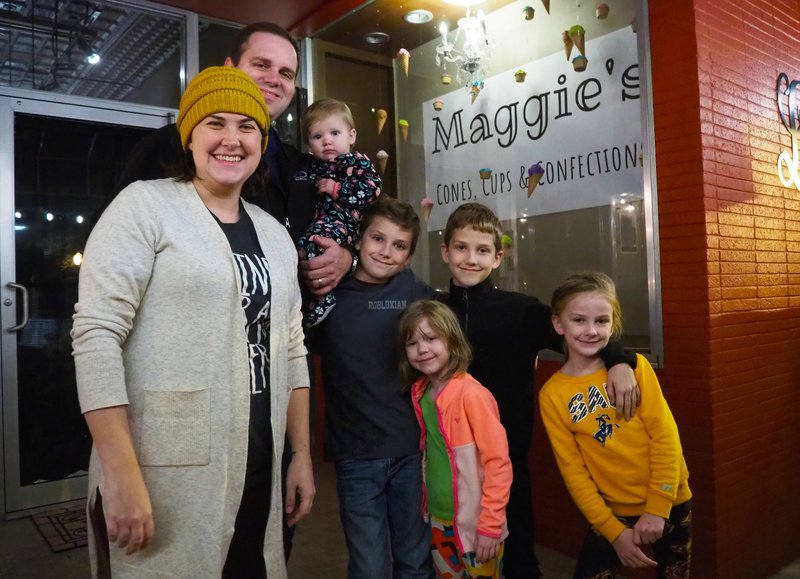 Pictured are Heather Becker (front left) and Jeffrey Becker (back left) with their family Thursday night just after the reveal of Maggie's Cups, Cones & Confections at 107 S. court Square. The husband and wife purchased the property in October and plan to convert the first floor of The Loft on the Square, a five-room guest suite hotel, into a "home-style" ice cream and treat shop by mid-January. 