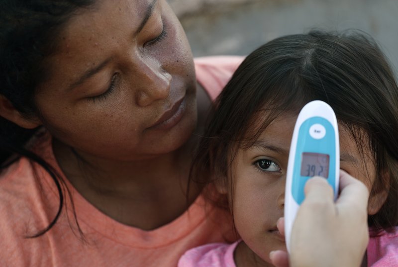 In this Tuesday, Nov. 5, 2019, photo, migrants see a health care worker as they receive medical care at a sidewalk clinic at a refugee camp in Matamoros, Mexico. The few doctors and nurses working in the camp are treating people including pregnant women and children with respiratory problems, skin conditions, diarrhea and other diseases that can be linked to the camp&#x2019;s unsanitary conditions. (AP Photo/Eric Gay)