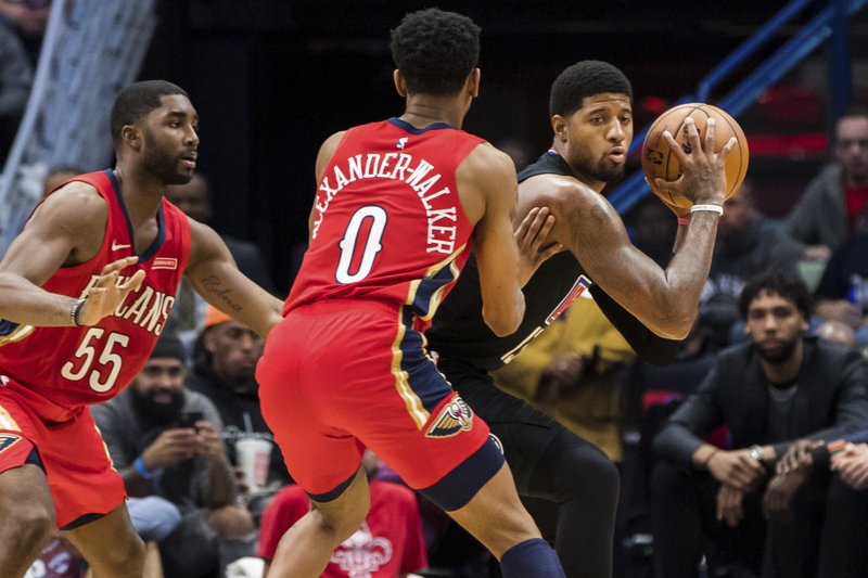 Los Angeles Clippers forward Paul George, right, keeps the ball away from New Orleans Pelicans guards E'Twaun Moore (55) and Nickeil Alexander-Walker (0) in the second half of Thursday's game in New Orleans. - Photo by Sophia Germer The Associated Press