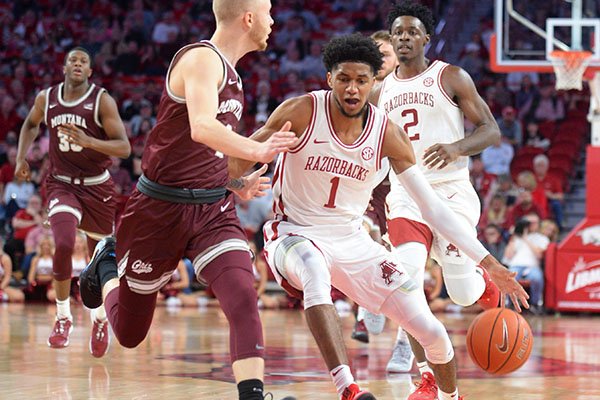 Arkansas guard Isaiah Joe (right) drives around Montana guard Timmy Falls Saturday, Nov. 16, 2019, during the second half of play in Bud Walton Arena in Fayetteville. 