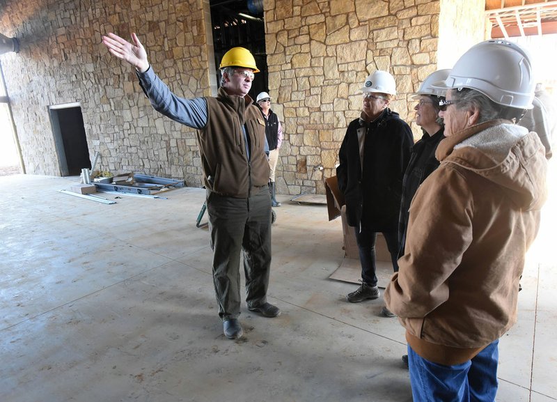 Eric Maynard (left), assistant education chief at Game and Fish, shows Friday tour visitors the indoor archery and airgun building at the Springdale nature center. The center is expected to open in October.