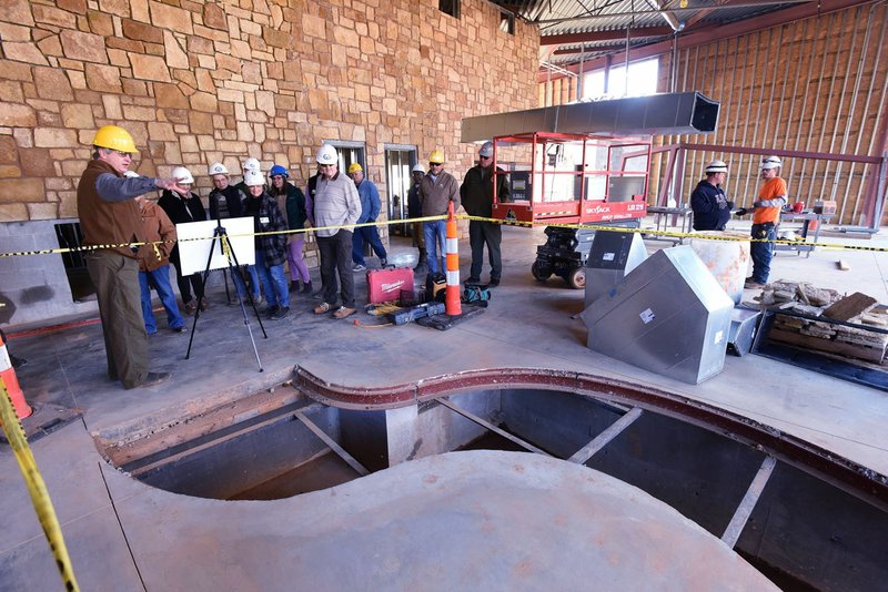 Eric Maynard (left), assistant education chief at Game and Fish, shows Friday an interactive stream feature being built at the Springdale nature center.