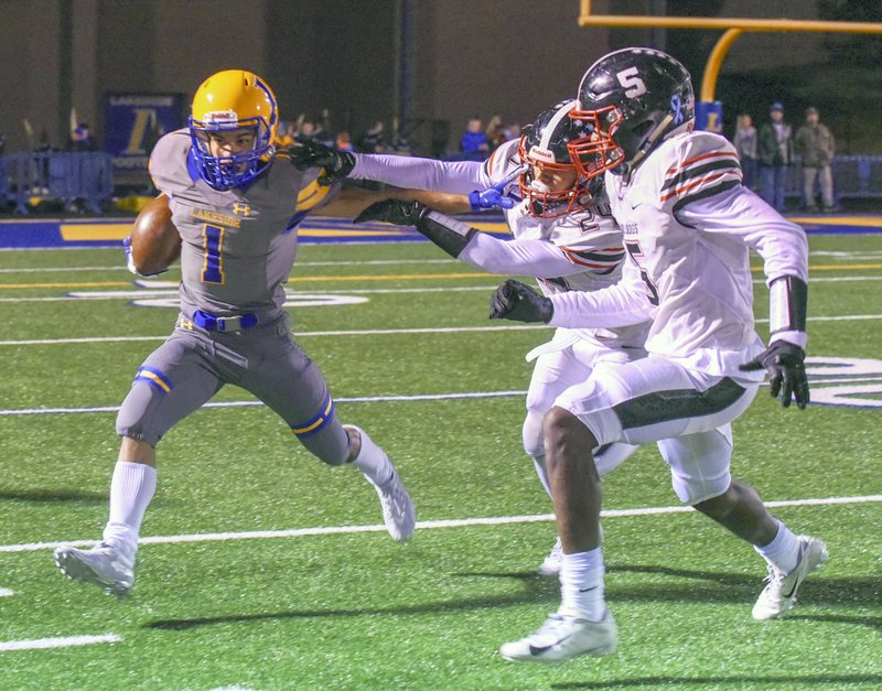 Junior Isaac Echols (1) breaks free as two White Hall players defend at Chick Austin Field Friday night. The Bulldogs won 35-0. - Photo by Grace Brown of The Sentinel-Record