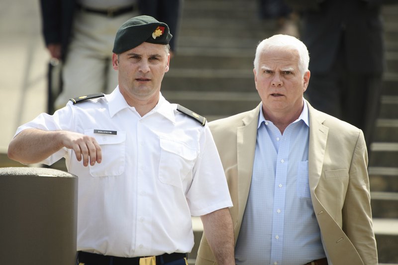 FILE - In this June 27, 2019, filke photo. Maj. Mathew Golsteyn, a former Army Special Forces soldier, leaves the Fort Bragg courtroom facility with his civilian lawyer, Phillip Stackhouse, right, after an arraignment hearing. President Donald Trump has pardoned a former U.S. Army commando set to stand trial next year in the killing of a suspected Afghan bomb-maker and for a former Army lieutenant who had been convicted of murder after he ordered his men to fire upon three Afghans, killing two, the White House announced late Friday. (Andrew Craft/The Fayetteville Observer via AP)