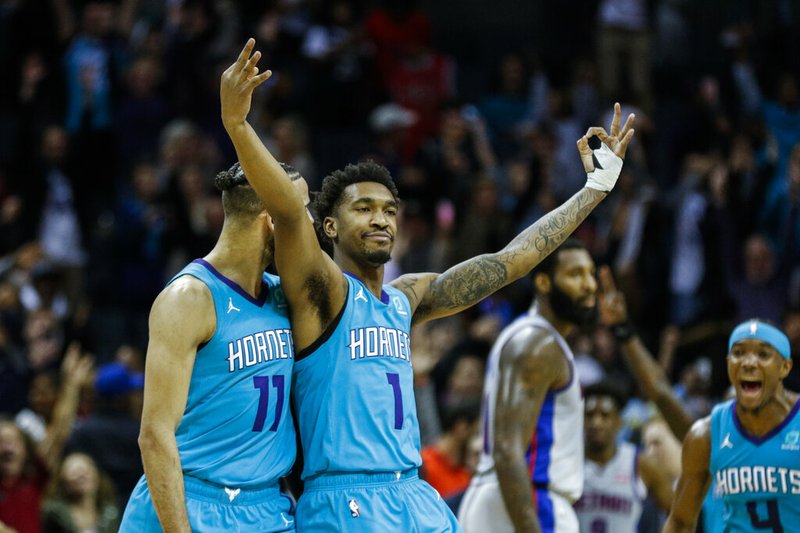 Charlotte Hornets guard Malik Monk, center, celebrates with teammate Cody Martin, left, after Monk hit a game-winning three-pointer as time expired in the second half of an NBA basketball game in Charlotte, N.C., Friday, Nov. 15, 2019. Charlotte won 109-106. (AP Photo/Nell Redmond)