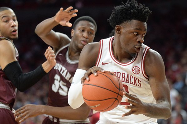 Arkansas forward Adrio Bailey (right) cuts to the basket Saturday, Nov. 16, 2019, past Montana Kendal Manuel (left) and Derrick Carter-Holilnger during the first half of play in Bud Walton Arena in Fayetteville. 