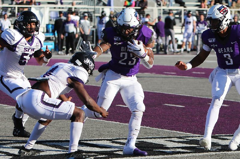 Central Arkansas running back Carlos Blackman (23) stiff-arms a Stephen F. Austin defender Saturday during the Bears’ 30-7 victory over the Lumberjacks at Estes Stadium in Conway. Blackman rushed for 83 yards and a touchdown on 16 carries.