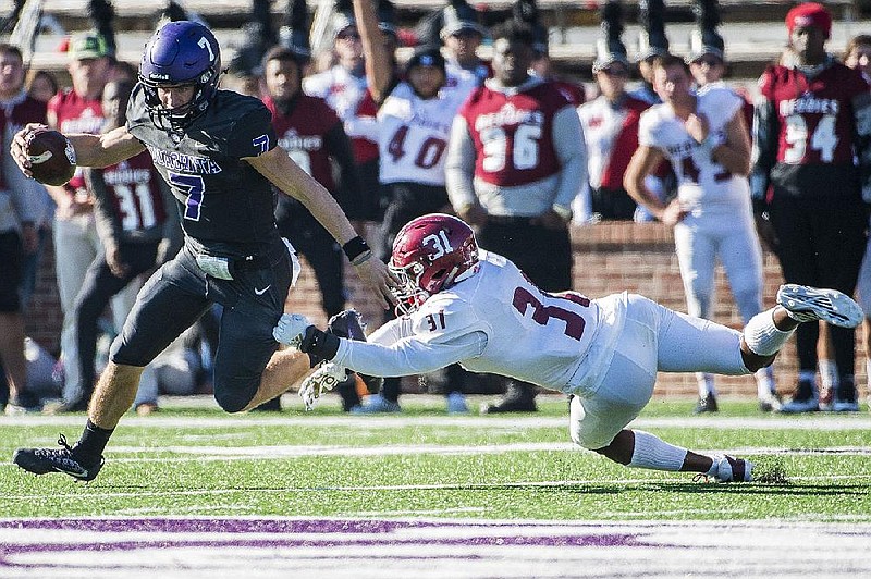 Ouachita Baptist quarterback Brayden Brazeal (left) avoids a sack attempt made by Henderson State defensive Mercado Anderson back during last year’s Battle of the Ravine. The GAC announced Friday it will delay the start of all sports practices until Aug. 31 and postpone any athletic competitions until Sept. 28.
(Arkansas Democrat-Gazette file photo)