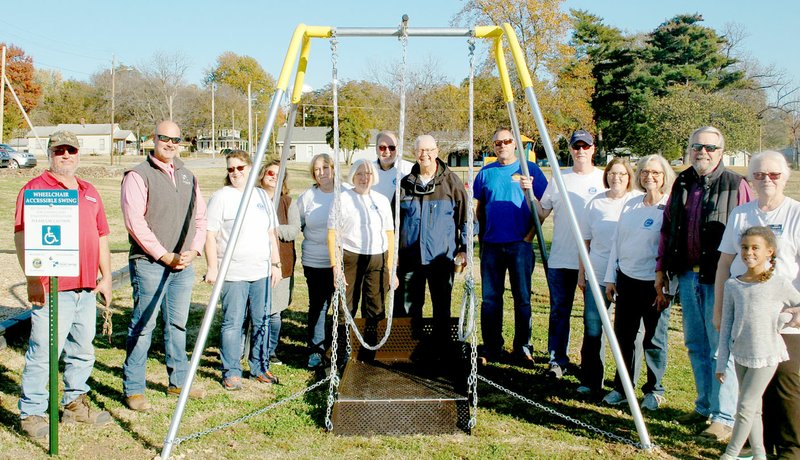 Marc Hayot/Herald Leader The Civitan Club donates a new handicapped accessible swing to the city of Siloam Springs on Nov. 8. The swing is located in Bob Henry Park. Pictured are Aaron Hollenback (left), Jon Bowles, Julia Siemens, Julie Conrad, Dixie Shoptaw, Awynne Thrustenson, Ric Stripling, Jerry Cavness, Steve Wilmott, Steve Thomas, Vicki Kincheloe, Louise Dunham, Mayor John Mark Turner, Doris Henderson and Kastyn Charlot.