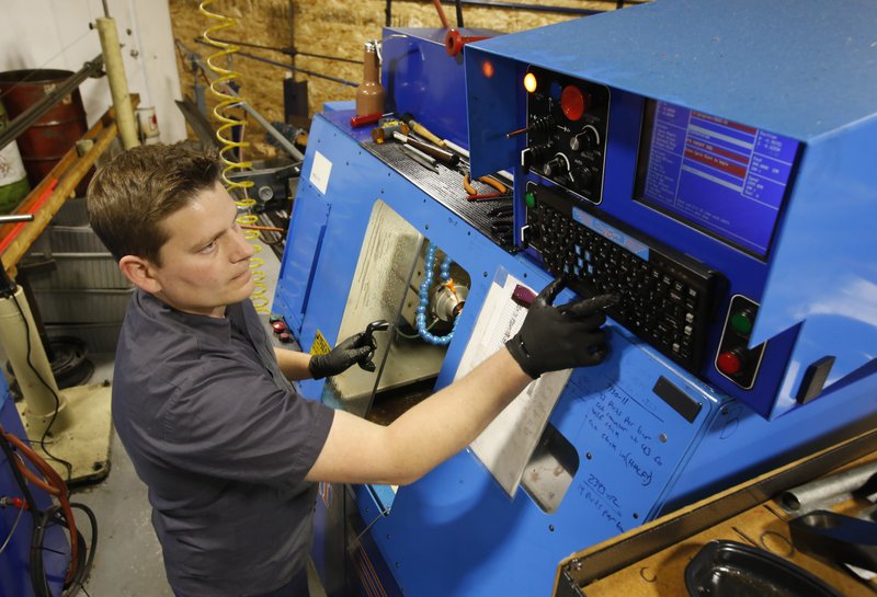 Kyle Chittock sets up a computerized lathe at his family’s manufacturing business, Simply Country, in Grass Valley, Calif., earlier this month. 