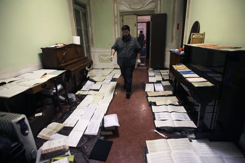 Volunteers try to save ancient music sheets by placing them to dry at the first floor of Venice Conservatory after recovering them from ground floor Saturday in Italy. High tidal waters returned to Venice on Saturday, four days after the city experienced its worst flooding in 50 years. Young Venetians are responding to the worst flood in their lifetimes by volunteering to help salvage manuscripts, clear out waterlogged books and lend a hand where needed throughout the stricken city. - AP Photo/Luca Bruno