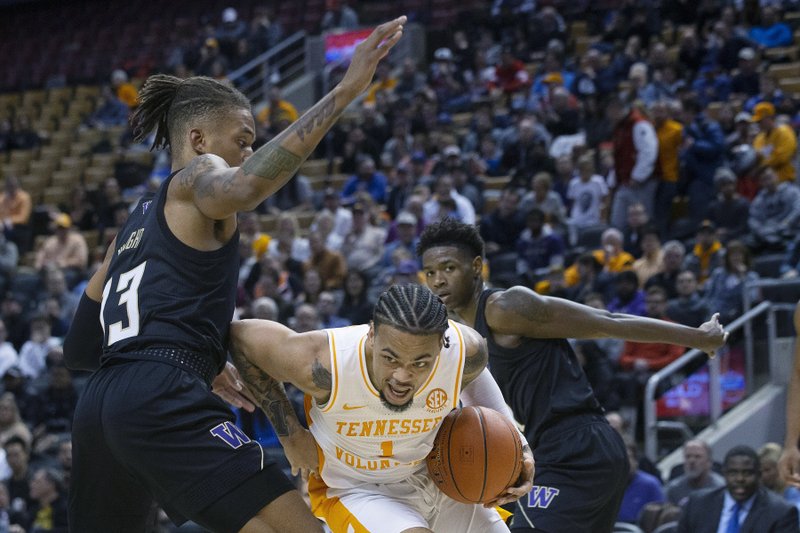 Tennessee's Lamonte Turner, center, drives past Washington's Hameir Wright during the first half of an NCAA college basketball game in the James Naismith Classic, in Toronto on Saturday, Nov. 16, 2019. (Chris Young/The Canadian Press via AP)