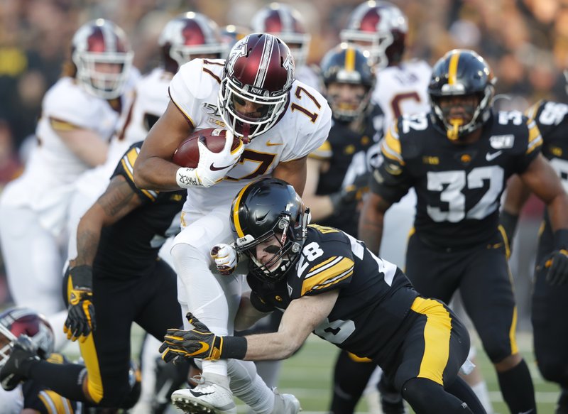 Minnesota wide receiver Seth Green (17), left, runs the ball as he is tackled by Iowa defensive back Jack Koerner during the first half of Saturday's game in Iowa City, Iowa. - Photo by Matthew Putney of The Associated Press