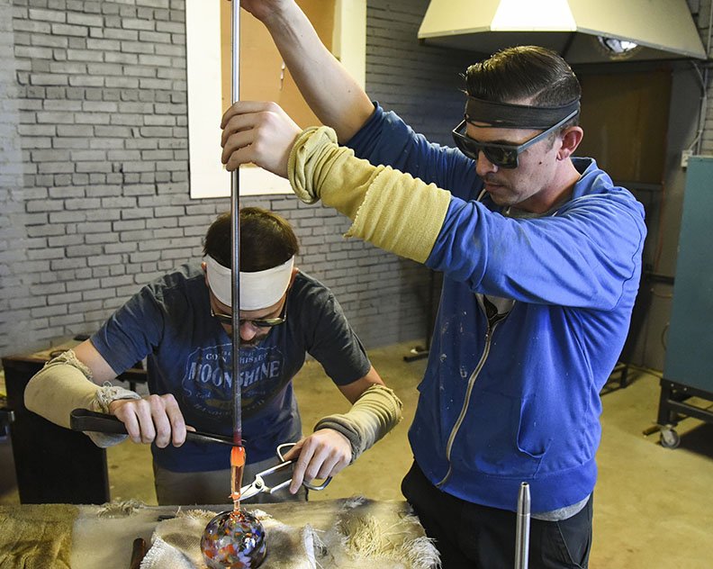 Michael, right, and Charles Riley create a glass Christmas ornament at Riley Art Glass Studio, 710 W. Grand Ave., on Nov. 12. - Photo by Grace Brown of The Sentinel-Record