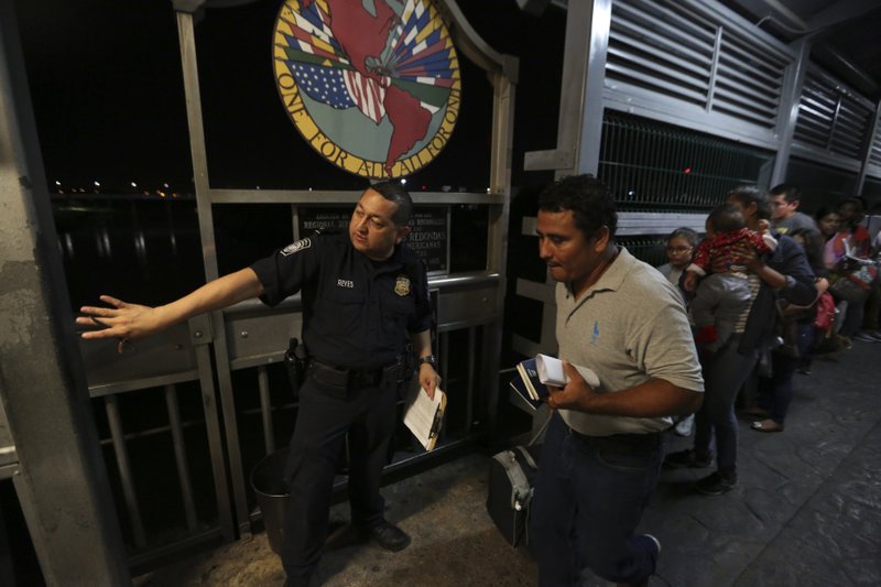 ADVANCE FOR USE SUNDAY, NOV. 17, 2019 AND THEREAFTER- In this Sept. 17, 2019 photo, a U.S. border patrol officer directs a Nicaraguan migrant family, who is applying for asylum in the U.S., over International Bridge 1 from Nuevo Laredo, Mexico into Laredo, Texas, for an interview with immigration officials. The U.S. has set limits on applicants for asylum, slowing the number to a mere trickle, while the policy known colloquially as &#x201c;Remain in Mexico,&#x201d; has meant the return of more than 55,000 asylum-seekers to the country while their requests meander through backlogged courts. (AP Photo/Fernando Llano)