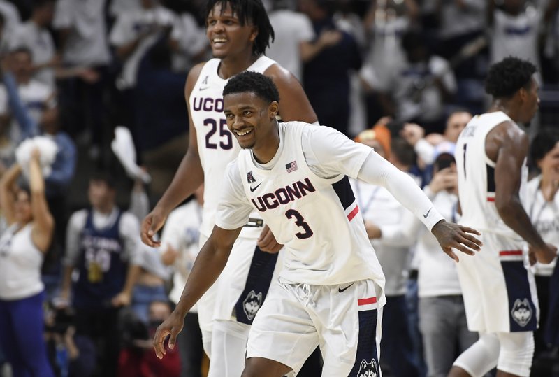 Connecticut's Alterique Gilbert (3) and Josh Carlton (25) celebrate at the end of an NCAA college basketball game against Florida, Sunday, Nov. 17, 2019, in Storrs, Conn. (AP Photo/Jessica Hill)